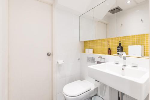 a white bathroom with a sink and a toilet at Surry Hills Terrace in Sydney