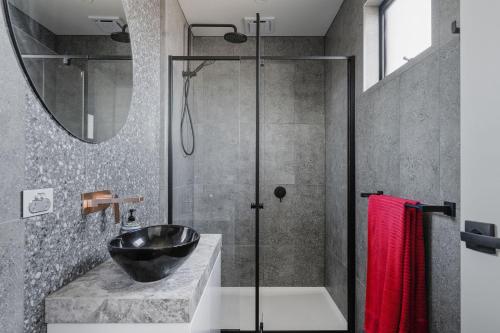 a bathroom with a sink and a glass shower at Smiths Island Retreat in Smiths Beach