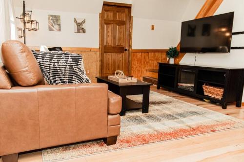 un soggiorno con divano e TV a schermo piatto di Whitts Acres Cabin*RRG/Cave Run* a Big Woods