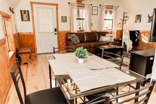 sala de estar con mesa y sofá en Whitts Acres Cabin*RRG/Cave Run* en Big Woods