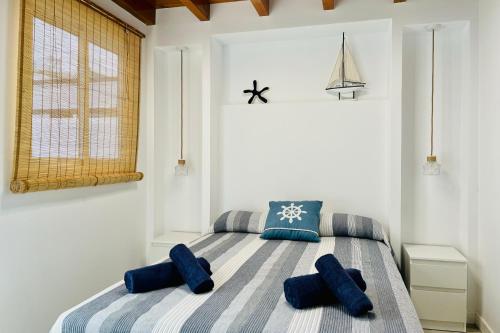 ein Schlafzimmer mit einem Bett mit blauen Kissen darauf in der Unterkunft El Castillito Studios in Buenavista del Norte