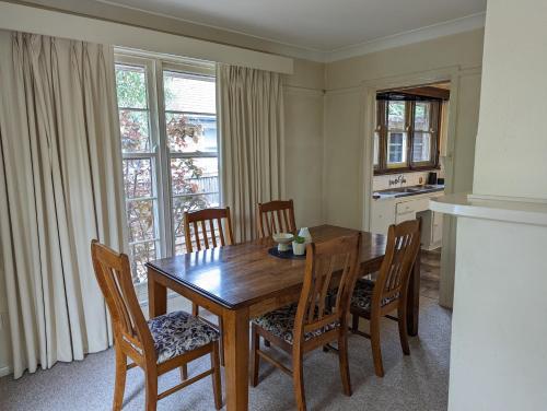 a dining room with a wooden table and chairs at A Classic Deakin Delight in Yarralumla
