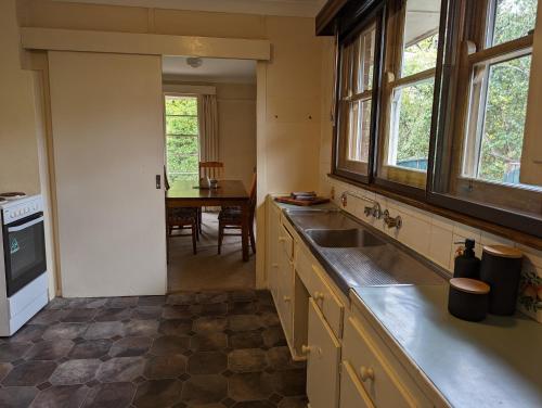 a kitchen with a sink and a table at A Classic Deakin Delight in Yarralumla