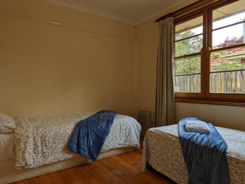 a bedroom with two beds and a window at A Classic Deakin Delight in Yarralumla