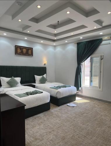 Habitación de hotel con 2 camas y ventana en فندق زوايا الماسية فرع الحمراء, en Medina