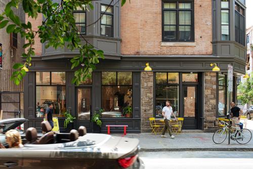 a building on a street with people sitting in a tub at YOWIE Hotel in Philadelphia