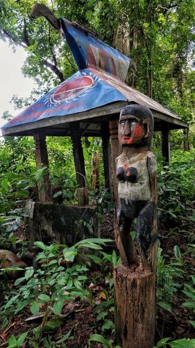a wooden statue sitting on top of a tree stump at Jar rai village homestay& Sona trekking tour in Banlung