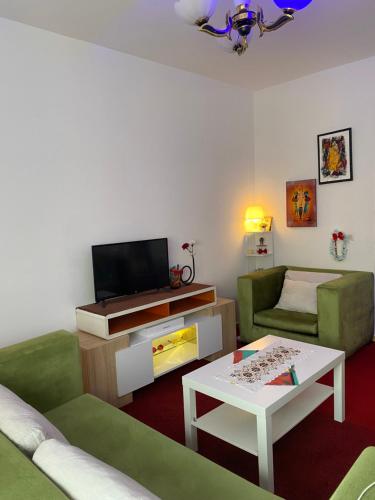 a living room with a tv and a couch and a table at Milz house in Salé