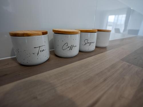 a row of four coffee cups sitting on a table at Best Western Ambassador Motor Lodge in Hervey Bay