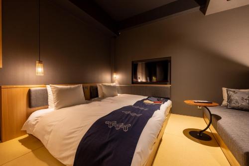 a bedroom with a large bed and a table at Hotel Zagakukan in Hakone
