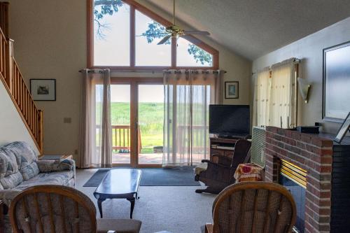 ein Wohnzimmer mit einem Kamin und einem TV in der Unterkunft Lakeview & Wildlife in Au Gres
