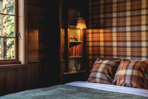 a bedroom with a bed and a plaid wall at Old Bishop's Quarters Hobart in Hobart