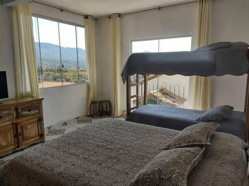 una camera da letto con due letti e una grande finestra di Casa Bela Vista a Tiradentes
