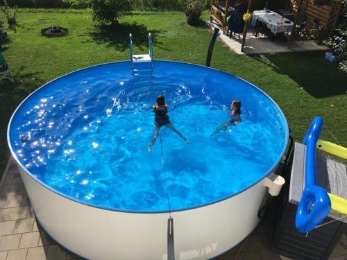 two people swimming in a large swimming pool at Ferienwohnung Bichler in Altötting