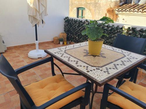 une table et des chaises avec une plante en pot dans l'établissement Casa da Vera, à Faro