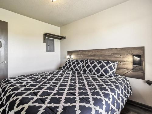 a bedroom with a bed with a black and white comforter at Freestanding 2 Bedroom Cabins 