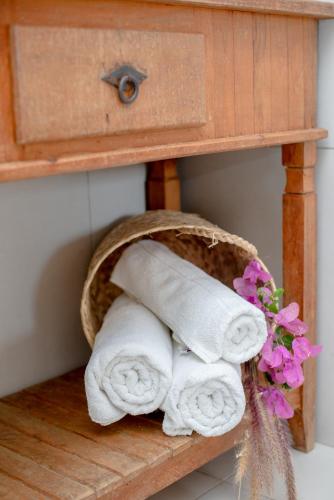 a basket of towels on a shelf next to a table at Villa Bella Ferradura in Búzios