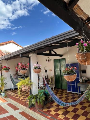 a porch with hammocks and potted plants on it at Green Door San Gil in San Gil