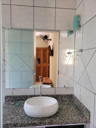 a bathroom with a sink and a mirror at Suítes Boa Viagem in Pirenópolis