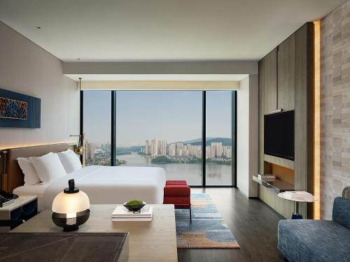 a hotel room with a bed and a large window at Hotel Indigo Changsha Meixi Lake in Changsha