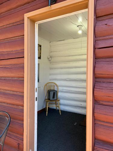 a door leading into a room with a chair at Faithful Street Inn in West Yellowstone