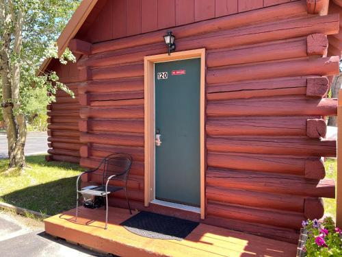 a door on the side of a house with a chair at Faithful Street Inn in West Yellowstone