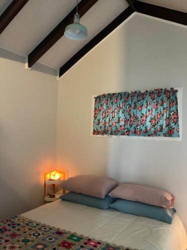 a bedroom with a bed with a painting on the wall at La Pequeña Escandinavia, Havethus in Dichato