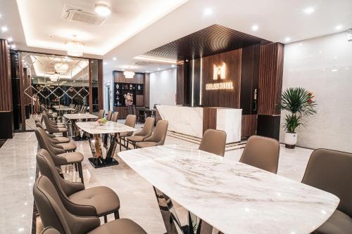 a restaurant with tables and chairs and a bar at Milan Hotel Ninh Bình in Ninh Binh