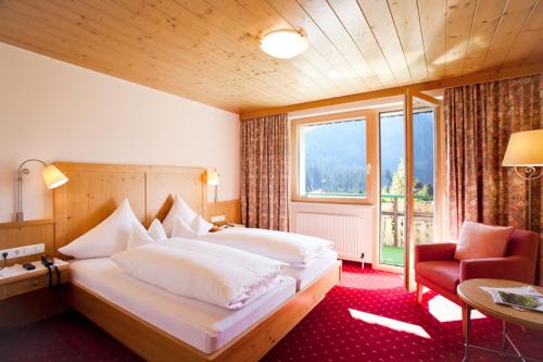 a bedroom with a large bed and a large window at Pension Waldhof in Lech am Arlberg