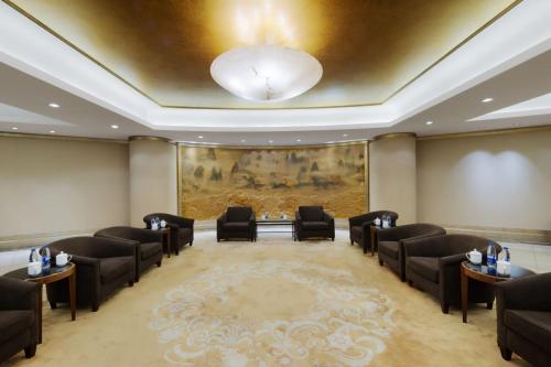 a waiting room with black chairs and a painting at DoubleTree by Hilton Shanghai Pudong - Present welcome cookie in Shanghai