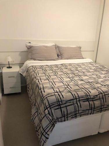 um quarto com uma cama com um edredão preto e branco em Royal Ibirapuera Park em São Paulo