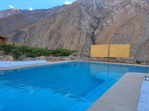 a swimming pool with a mountain in the background at Samay Lodge in Cochiguaz