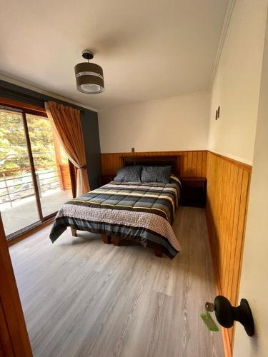 a bedroom with a bed and a large window at 215 Cacique Catrini in Licán Ray