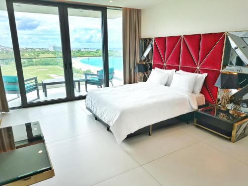 a bedroom with a large bed with a red headboard at Mullet Bay Suites - Your Luxury Stay Awaits in Cupecoy