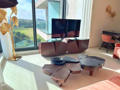 a living room with a table and chairs and a television at Mullet Bay Suites - Your Luxury Stay Awaits in Cupecoy