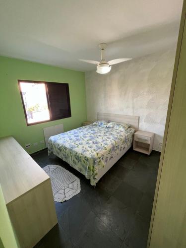 a bedroom with a bed and a window at Guarujá enseada, apto a 150m da praia. in Guarujá