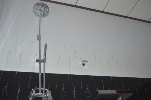 a shower in a bathroom with a black and white wall at Amazon Cabanas in Tissamaharama