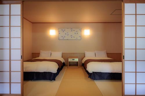 a room with three beds in a room at Kifuno Sato in Mimasaka