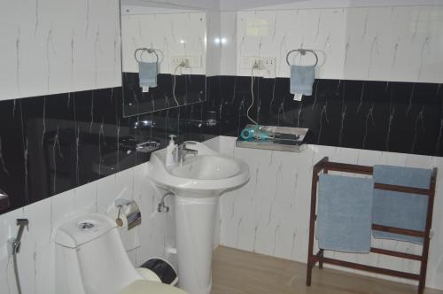 Baño blanco con lavabo y aseo en Amazon Cabanas en Tissamaharama