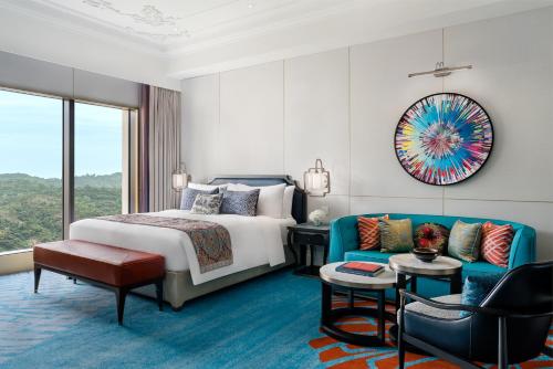 um quarto de hotel com uma cama e um sofá em Grand Lisboa Palace Macau em Macau