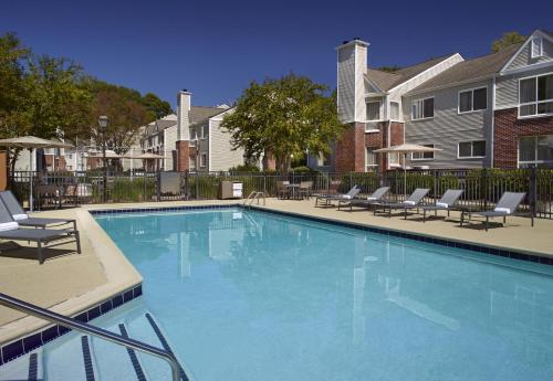 a large swimming pool with chairs and a house at Trellis Durham RTP in Durham