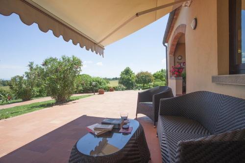 a patio with two chairs and a table with a glass at Agriturismo Verbena in Castiglione del Lago