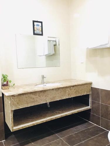 a bathroom with a sink and a mirror at Quê Tôi Hotel in Soc Trang