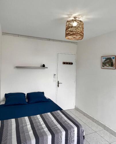 a bedroom with a blue bed and a white wall at L'Escale, appt partagé, shared apartment in Pointe-à-Pitre