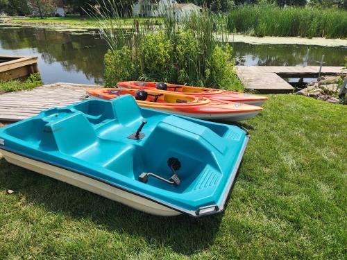 two boats sitting on the grass next to a dock at NEW! Lake Winnebago Waterfront Retreat in Oshkosh