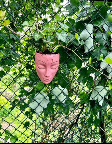 a pink vase sitting on top of a fence at 10-A Diamond in Yonkers, NY in Yonkers