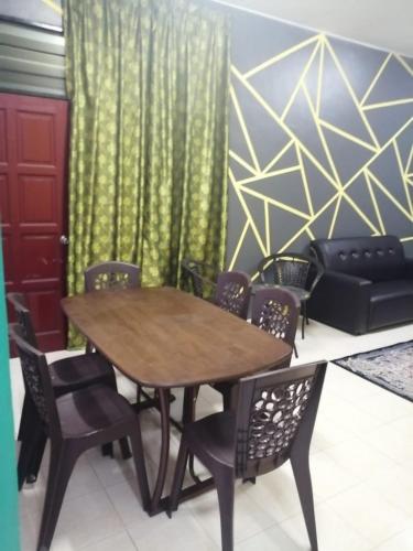 einen Tisch und Stühle in einem Zimmer mit Sofa in der Unterkunft Iman Guesthouse in Jitra