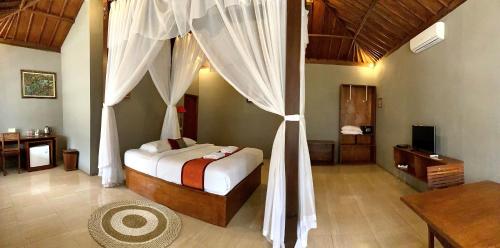 a bedroom with a bed with a canopy at Kampoeng Joglo Ijen in Banyuwangi