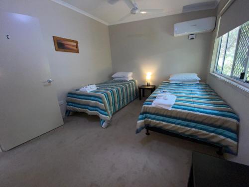 a room with two beds and a window at Honeybee Wellness Resort in Kandanga