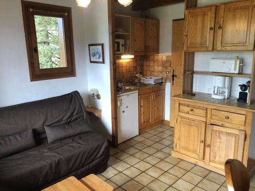 a living room with a couch and a kitchen at Appartement Notre-Dame-de-Bellecombe, 2 pièces, 4 personnes - FR-1-595-86 in Notre-Dame-de-Bellecombe